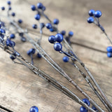 Deep blue faux berries on frosted twig branches