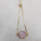 Rose Quartz square slider bracelet laid flat on linen, showing the gold box chain