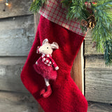 Close-up of the mouse in a red and tartan outfit on the red Christmas stocking