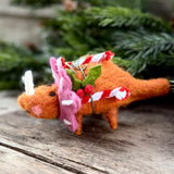 Orange felt triceratops with pink frill holding a candy cane