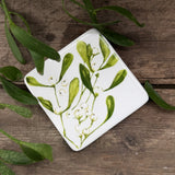 White ceramic coaster with green mistletoe design and cork base, additional view