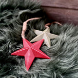 Red and sage green wooden star decorations on faux fur