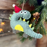 Pale blue felt dinosaur with yellow belly and Santa hat