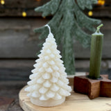 White Christmas tree candle on a wooden board