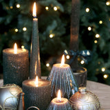 Lit forest green sparkly cone candles with baubles