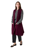 Model wearing the merlot doubleknit roll collar gilet over a patterned blouse, side view