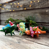 Felt stegosaurus, T-rex and triceratops Christmas decorations in a row
