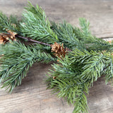 Close-up of lifelike faux fir needles and pine cones