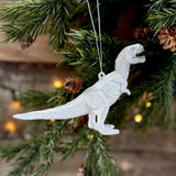 Silver T-rex dinosaur decoration hanging on a Christmas tree