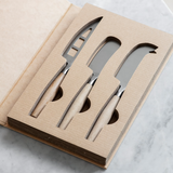 Set of knives with wooden handles in a cardboard packaging on a marble surface