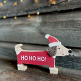 Wooden sausage dog Christmas decoration on a wooden shelf
