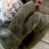 Close-up of a soft olive green faux fur mitten