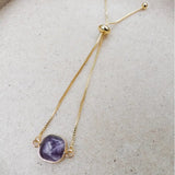 Purple Amethyst square slider bracelet laid flat on linen with gold slider chain