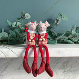 Two red sitting mice with long dangly legs on a marble mantelpiece
