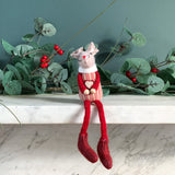 Red sitting mouse in a gingham top with long red legs on a mantelpiece